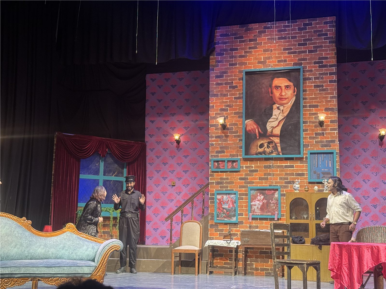 Actors performing beneath the large portrait on the set